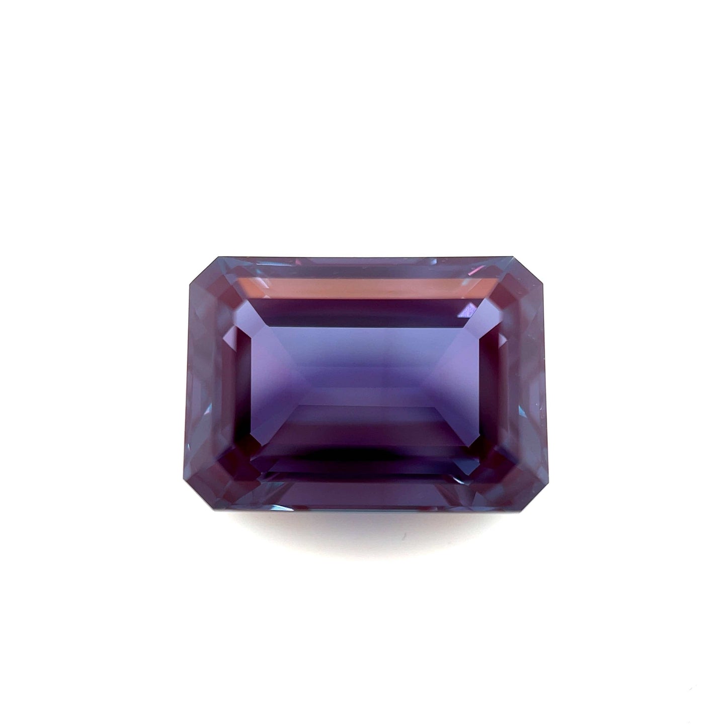 The 14.0x10.0 Exceptional Emerald Lab Created Alexandrite features an emerald shape with deep purple and blue hues, showcased against a white background.