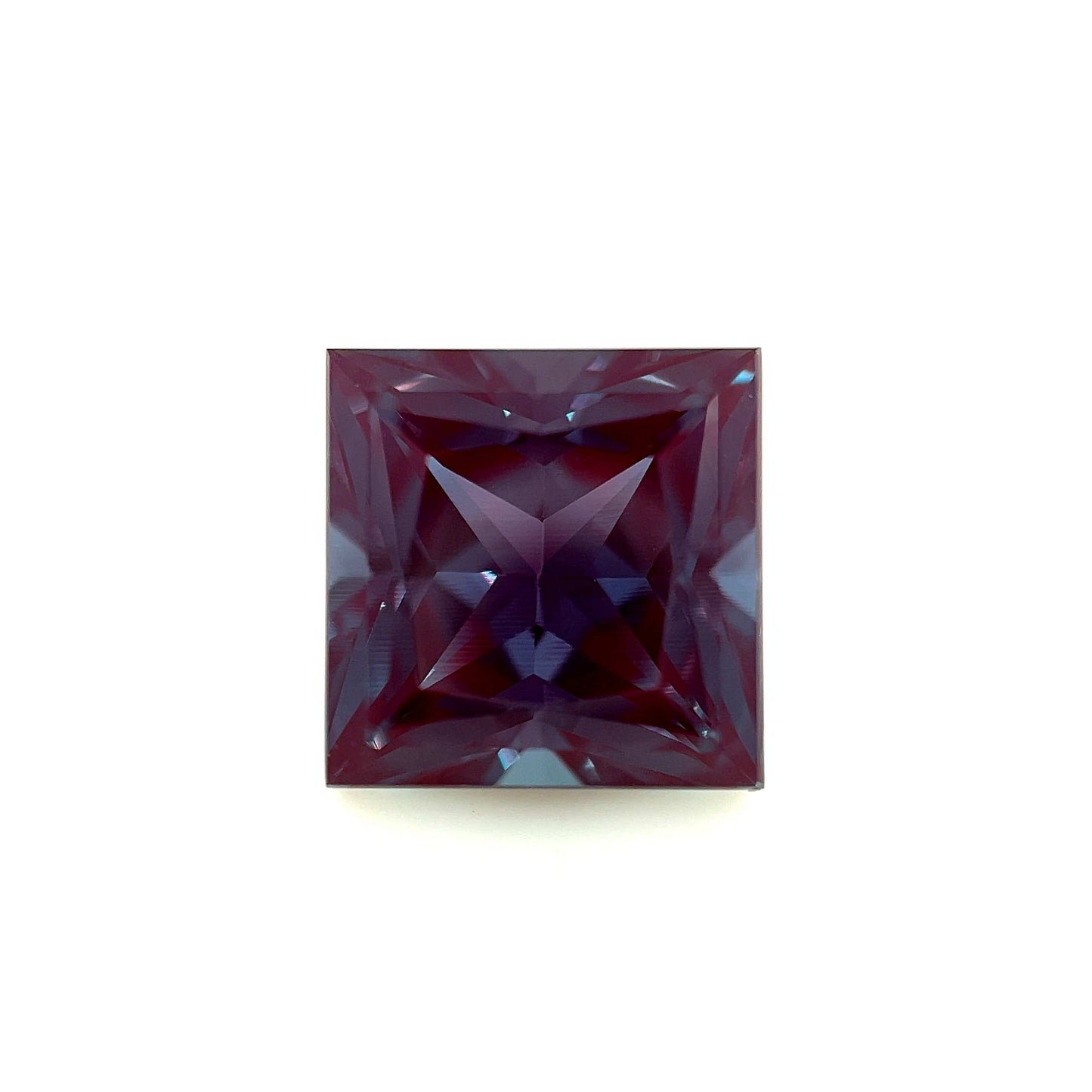 The 10mm Exceptional Square Princess Lab Created Alexandrite features a deep purple hue and intricate facets that reflect light in geometric patterns, set against a plain white background.