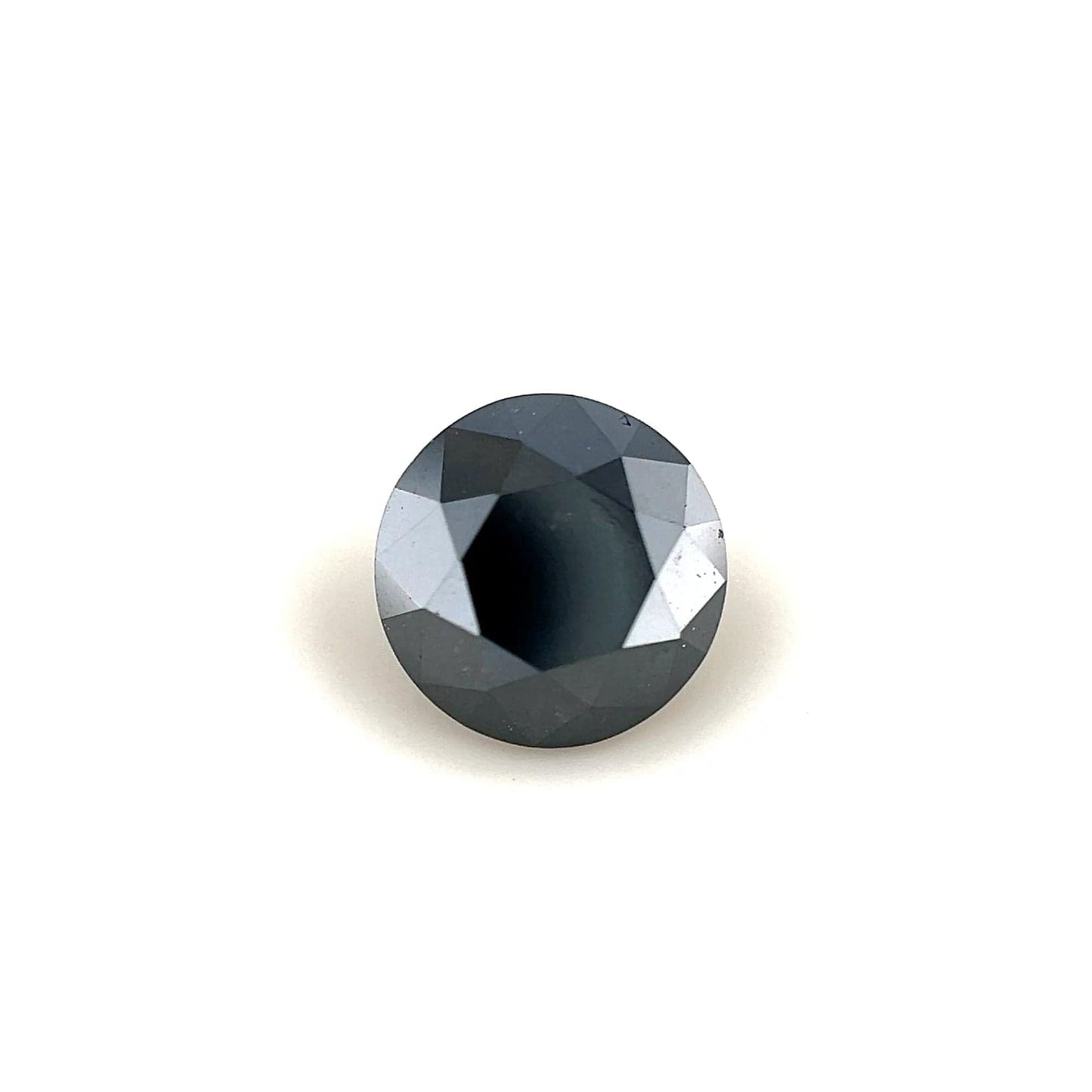 A 1.40 carat, round faceted black diamond (6.65 x 6.65 x 4.87 mm) with a reflective surface is showcased against a plain white background.