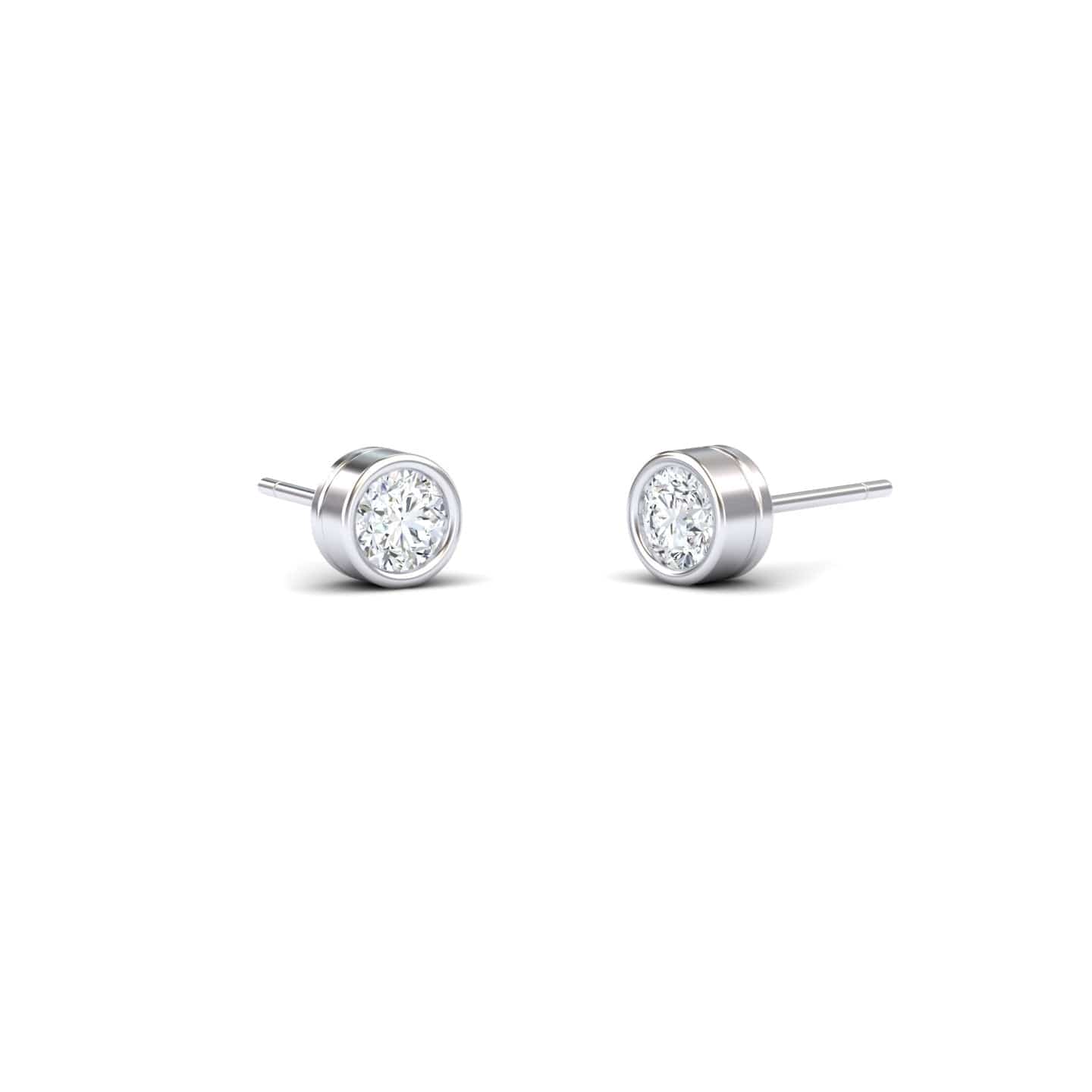 A pair of Lab Diamond Earrings - Bezel Set - Ishanvi, featuring round clear lab diamonds in sleek silver bezels, displayed on a plain white background.