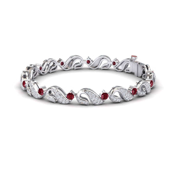 The Ruby & Diamond Swirl Link Bracelet - Elizabeth features an intricate leaf pattern with sparkling white stones and round red gemstones, beautifully displayed against a white background.