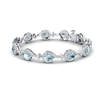 The Aquamarine & Diamond Tennis Bracelet - Gemma features alternating pear-shaped and round light blue aquamarines, each encircled by sparkling diamonds, all set in silver with a secure clasp.