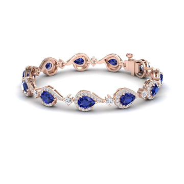 The Blue Sapphire & Diamond Tennis Bracelet - Gemma features teardrop-shaped blue sapphires encircled by sparkling diamonds, linked in an elegant rose gold design with a secure clasp.