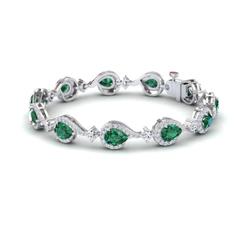 The Emerald & Diamond Tennis Bracelet - Gemma showcases alternating oval and pear-shaped green gemstones, each encircled by sparkling diamonds, linked in an elegant, flowing design.