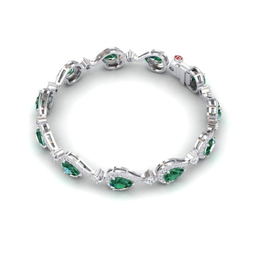 The Emerald & Diamond Tennis Bracelet - Gemma showcases oval green gemstones framed by white diamonds in a continuous silver design, displayed on a white background.