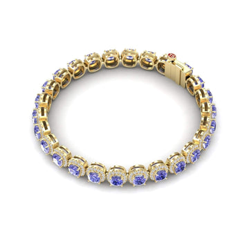 The Tanzanite & Diamond Halo Tennis Bracelet - Isabella showcases a row of round blue gemstones in prong settings with a secure clasp, elegantly displayed on a white background.
