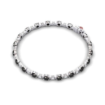 The Black & White Diamond Tennis Bracelet - Natalia features alternating round black and clear gemstones set in silver, evenly spaced along the length, and finished with a sleek clasp.