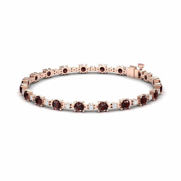 The Garnet & Diamond Tennis Bracelet - Natalia features round, deep red garnets set in a single row with prong settings and a secure clasp in rose gold.