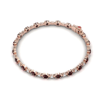 The Garnet & Diamond Tennis Bracelet - Natalia features alternating round red garnets and small square white diamonds in a rose gold setting, arranged in a circle with a secure clasp.