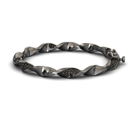 The Black Diamond Twisted Bangle Bracelet - Dakota features a sleek metallic design with embedded dark stones, a twisted motif, and a secure clasp for an elegant, modern look.