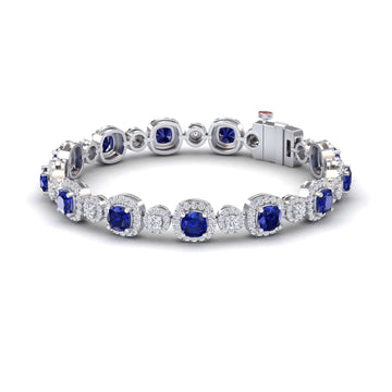 The Lab Grown Blue Sapphire & Diamond Tennis Bracelet - Erina features alternating round blue sapphires and diamond clusters in a secure, elegant, and symmetrical design that showcases the gemstones in a continuous loop.