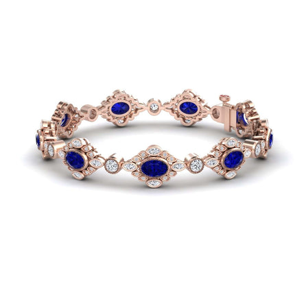 The Ariana Blue Sapphire & Diamond Vintage-Inspired Tennis Bracelet features oval blue sapphires and round white diamonds in an ornate design, showcased on a white background.