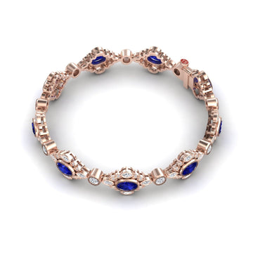The Blue Sapphire & Diamond Vintage-Inspired Tennis Bracelet - Ariana showcases oval blue sapphires and round white diamonds in ornate rose gold links, elegantly displayed on a white background.