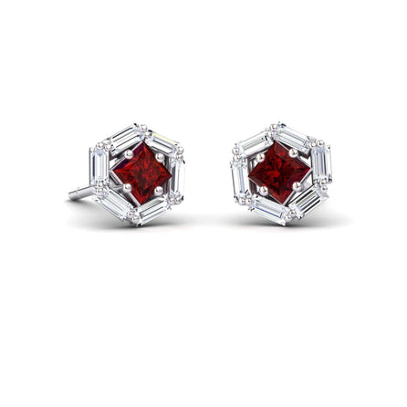 The Ruby & Diamond Hexagon Halo Stud Earrings - Kiara feature a square-cut deep red gemstone at the center, surrounded by hexagonal baguette-cut clear stones, all set in shimmering white metal.