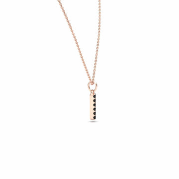 The Black Diamond Vertical Bar Necklace - Lalita is a delicate rose gold necklace with a vertical rectangular pendant featuring a row of small black diamonds on one side, shown against a plain white background.