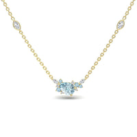 The Aquamarine & Diamond Bouquet Necklace - Daria features a gold chain with a central heart-shaped aquamarine surrounded by diamonds and two marquise-cut gemstone accents on each side.