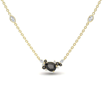 The Black & White Diamond Bouquet Necklace – Daria features a gold chain with a central oval black gemstone, surrounded by black and white stones, plus two marquise-shaped white stones set along the chain.