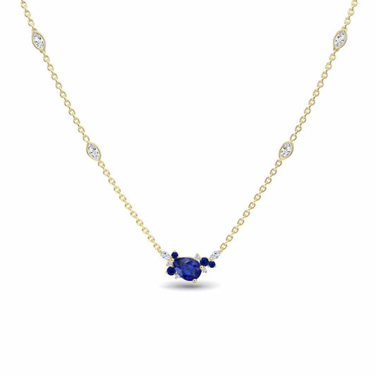 The Blue Sapphire & Diamond Bouquet Necklace - Daria features a central oval blue sapphire flanked by smaller sapphires and diamonds, with additional small diamonds set along its elegant gold chain.