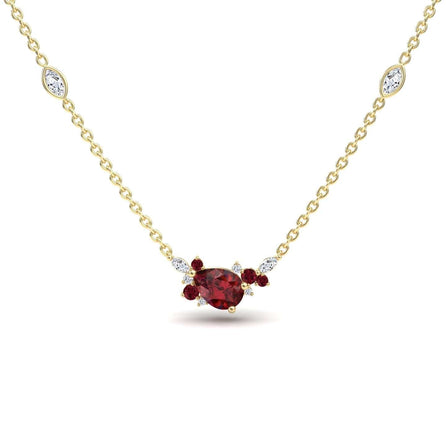 The Ruby & Diamond Bouquet Necklace - Daria features a gold chain with a pear-shaped red centerpiece, small white and red accent stones, and two marquise-cut white stones set along the chain.