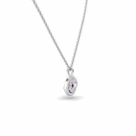 The Ruby & Diamond Eye Necklace - Elise is a silver necklace with a round, textured pendant featuring a central red gemstone and small clear stones, shown against a plain white background.