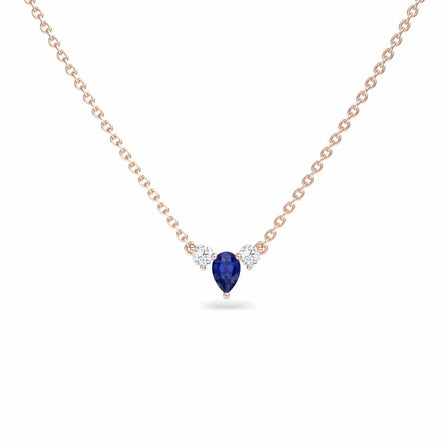 The Blue Sapphire & Diamond Three-Stone Necklace - Jina showcases a teardrop-shaped blue sapphire pendant flanked by two round diamonds, all set on a delicate gold chain against a white background.