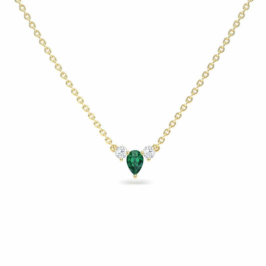 The Emerald & Diamond Three-Stone Necklace - Jina features a gold chain with a pear-shaped green gemstone pendant accented by two small round white gemstones on each side, shown against a white background.