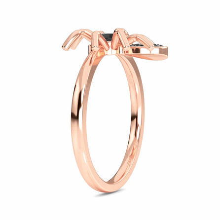 The Black Diamond Spider Statement Ring - Ainsley is a rose gold ring with a thin band and a decorative spider-shaped centerpiece, shown in side view on a white background.