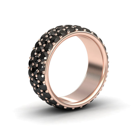 The Leila Black Diamond Three Row Pave Set Wedding Band features rows of small round black diamonds set in wide rose gold, creating a bold, luxurious look. The ring is displayed upright on a white background.