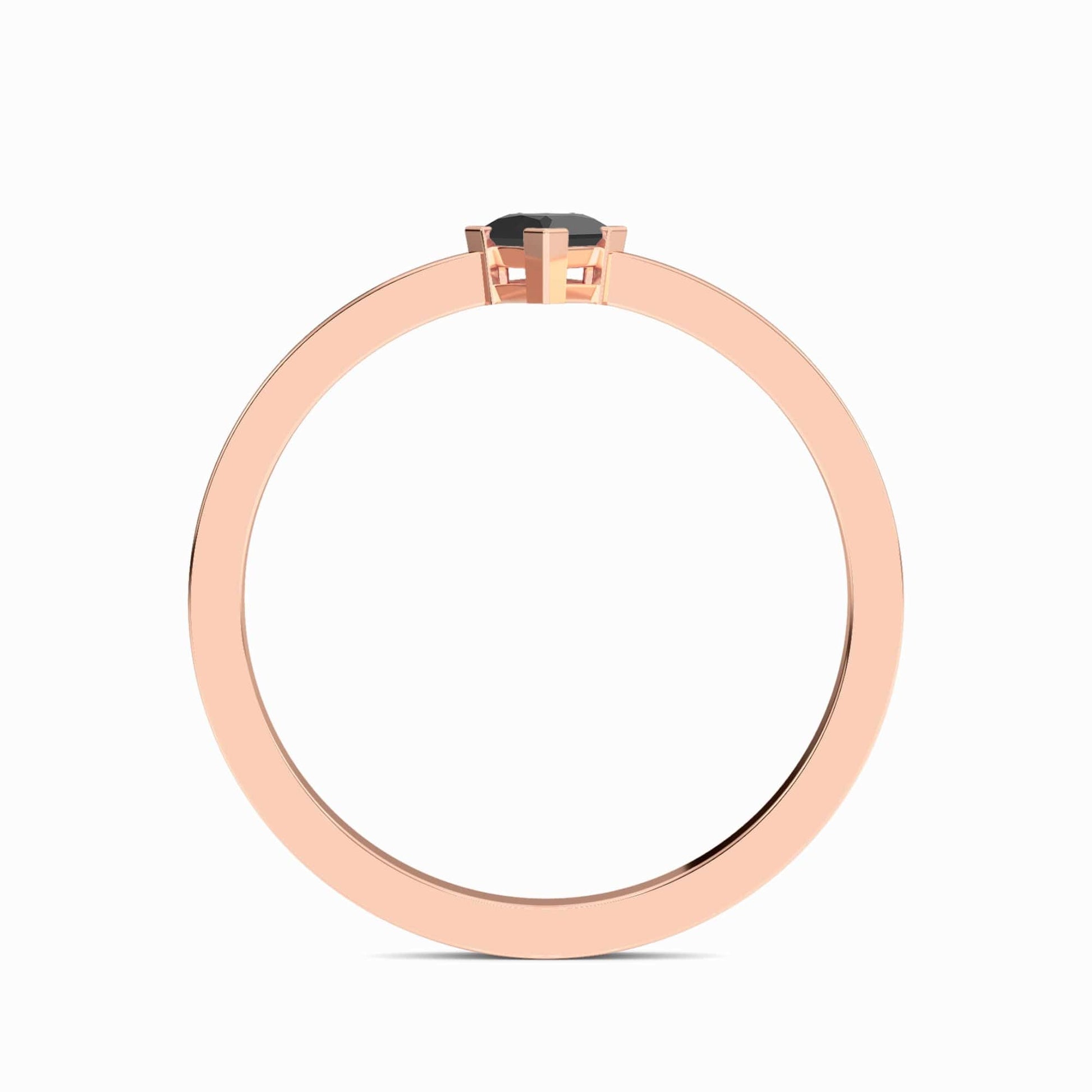 The Black Diamond Triangle Statement Ring - Shalini features a rose gold band with a single black diamond in a minimalist prong setting, displayed from the side against a white background.