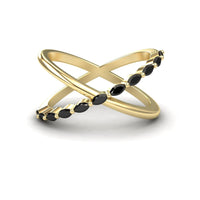 The Gracie Black Diamond Crossover Ring features gold bands in a crisscross design, with one band adorned by marquise-shaped black stones, displayed on a white background.