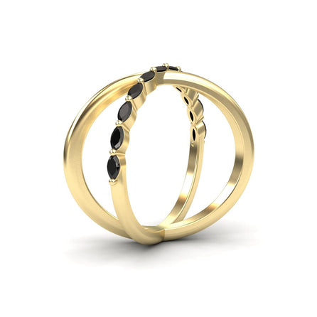 The Black Diamond Crossover Ring - Gracie features a minimalist gold design with five small black gemstones along the top, shown upright and leaning together on a white background.