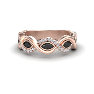 The Selma Black & White Diamond Infinity Twist Band features a rose gold infinity loop with three marquise black stones and white diamond accents, beautifully displayed on a white background.