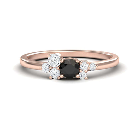 The Black & White Diamond Cluster Ring - Liana features a rose gold band with a round black center stone and asymmetric white diamond accents in minimalist prongs.