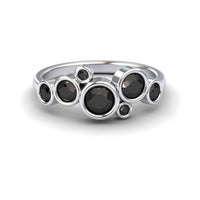 The Black Diamond Bubble Ring - Carmen features seven round black diamonds in varying sizes, each set in a bezel and arranged in an asymmetrical, clustered design.