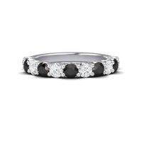 The Parveen Black & White Diamond Half Eternity Wedding Ring features alternating round black and white diamonds set in a continuous silver band.