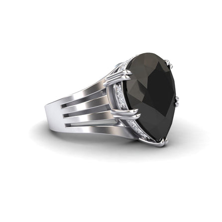 The Black & White Diamond Regal Ring - Anna is a silver ring with a large faceted oval black gemstone center, secured by four prongs and accented with small white diamonds along the sides.