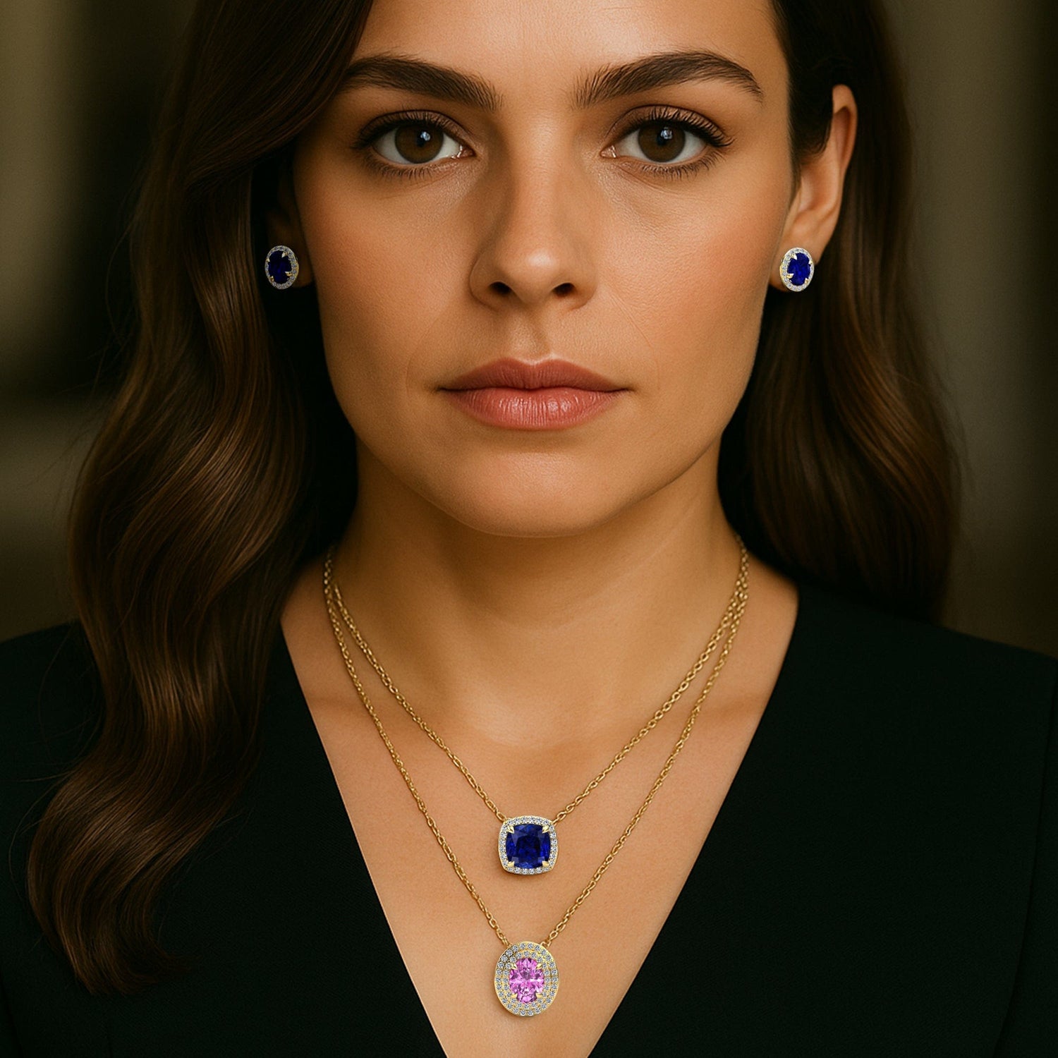 Woman wearing a gold necklace with a lab grown sapphire gemstone pendant and matching earrings.