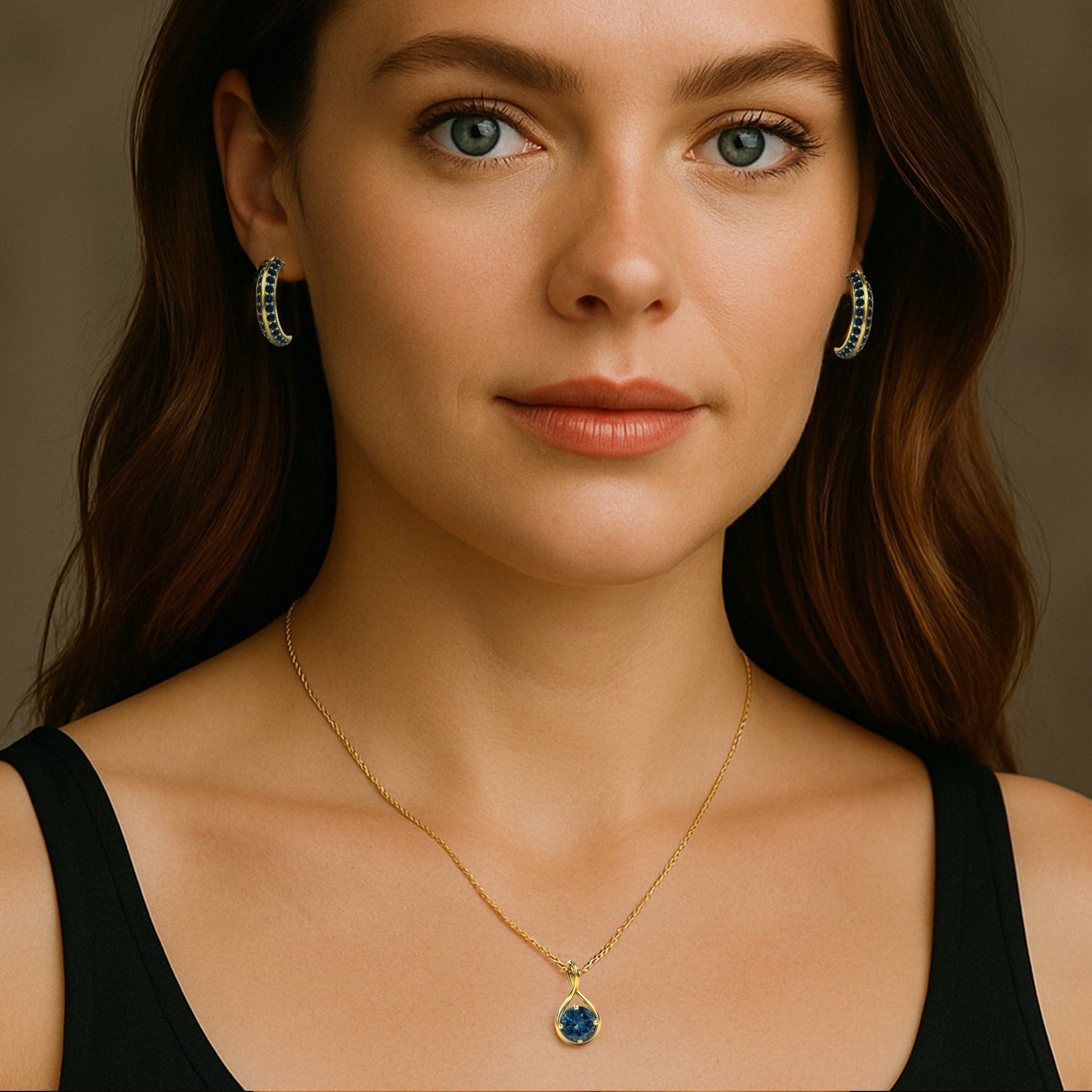 Woman wearing a gold necklace with a blue diamond pendant against a neutral background