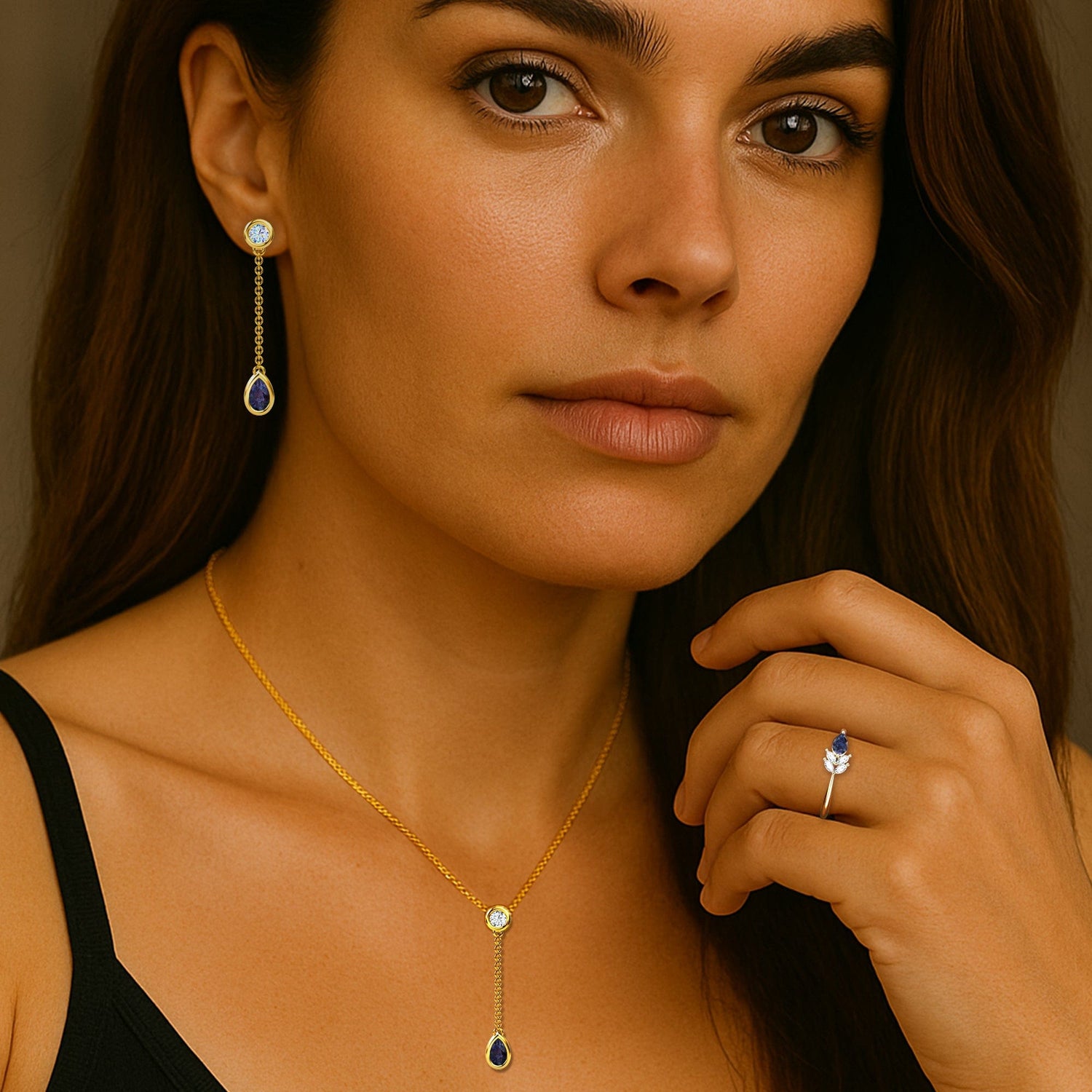 Woman wearing gold lab grown alexandrite necklace and earrings with a ring, against a neutral background