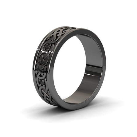 The Black Diamond Celtic Knot Wedding Band - Li Mei features an engraved Celtic knot pattern around a polished black band, displayed on a white background.