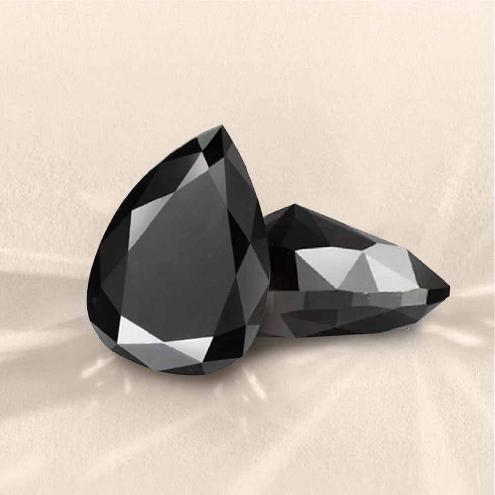 Two black teardrop-shaped diamond on a beige background