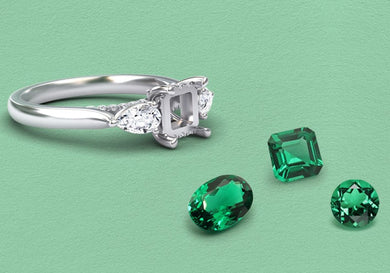 Silver ring with emerald gemstones on a green background