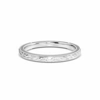 A vintage milgrain scroll wedding band in 14k white gold with engraved patterns around the circumference.