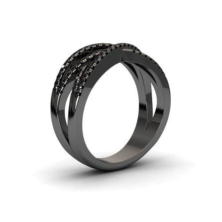 The Black Diamond Criss-Cross Pave Band Ring - Eden is a modern black metal ring with an open, overlapping band and rows of small black stones on one side, shown against a white background.