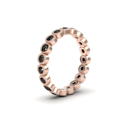 The Black Diamond Milgrain Bezel Set Eternity Band - Ira is a rose gold ring with round bezel-set black stones, each framed by a textured milgrain edge for a modern, elegant look.