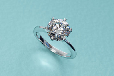 A close-up of a solitaire diamond engagement ring.