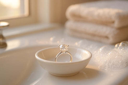 Diamond engagement ring in a white dish beside a sink.