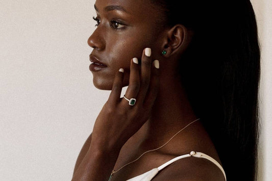 Woman showing emerald engagement ring