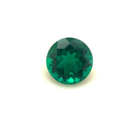 A 7mm Exceptional Round Zambian Color Lab Created Emerald, brilliant cut and faceted, shown on a plain white background.