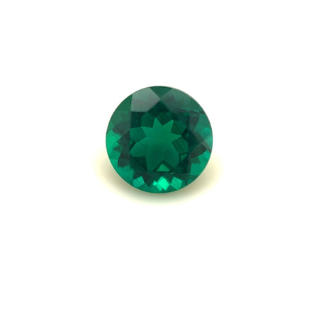 A 7mm Exceptional Round Zambian Color Lab Created Emerald, brilliant cut and faceted, shown on a plain white background.
